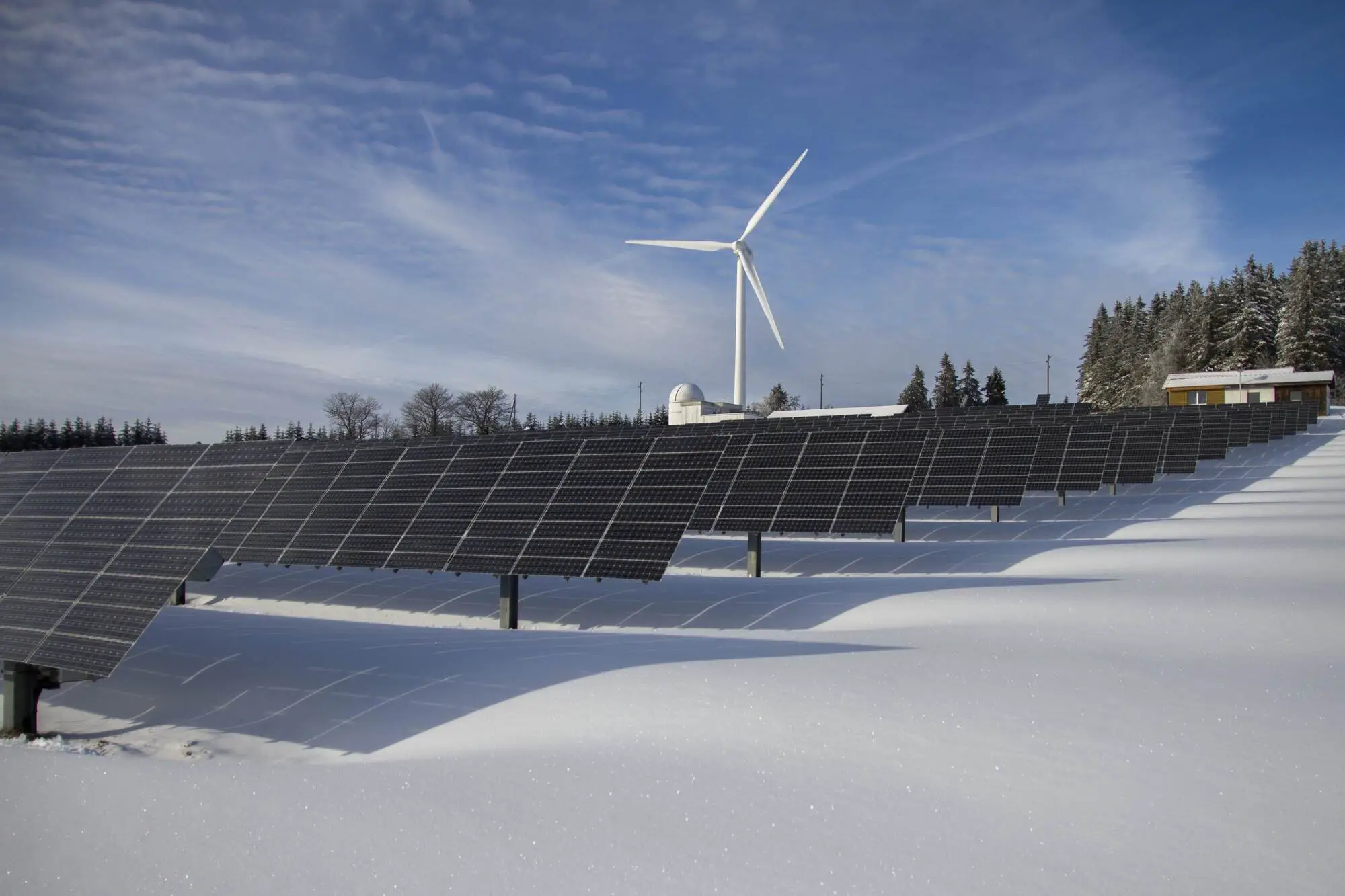 Solar panels with a turbine in the background