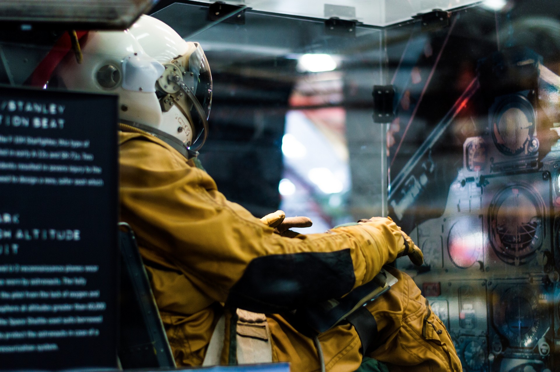 Person in astronaut suit sitting in a device